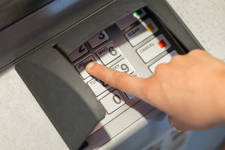 Woman entering her pin code number to atm machine. Money and cash withdrawal concept. Hand on...