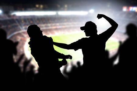 Fight in a football game crowd. Angry man hitting another spectator in soccer match audience....
