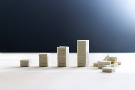 Bankruptcy, recession, inflation and business going down and collapse concept. Total breakdown and failure after growth. Company having bad luck. Going bankrupt. Stack of tiles crashing and falling.の写真素材