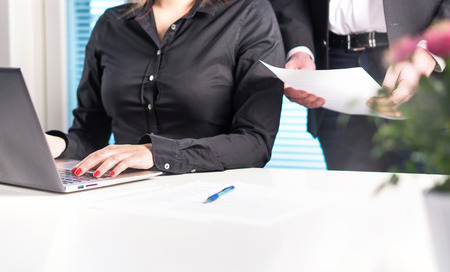 Team of lawyers or business people working together. Boss or executive manager holding and reading...