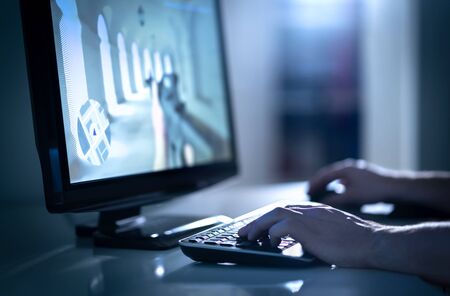 Man playing fps video game with desktop computer. E sports professional in competitive event. Team strategy and battle videogame streaming. Esports competition or stream concept. Gamer guy and player.の写真素材