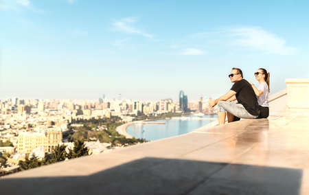 Tourists looking at the city of Baku. Historic old town and boulevard park in the background....