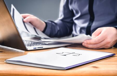 Attorney, prosecutor or solicitor working with legal papers in law firm and company. Busy lawyer with brief documents, agreement and contract. Jurist with laptop in office. Court, justice and businessの写真素材