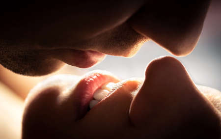 Couple kissing. Close up of lips. Man and woman having sex. Romantic love, passionate temptation and chemistry. Foreplay, intimacy or erotic sexual fantasy.の写真素材