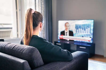 Tv news. Woman watching television broadcast in home living room. Reporter, anchor and studio host...