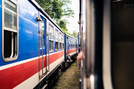 Two trains in Sri Lanka waiting at station. Railway travel and rail tourism. Old colorful blue and red heritage coach. Railroad in Ceylon. Journey from Colombo to Kandy and Ella.の写真素材