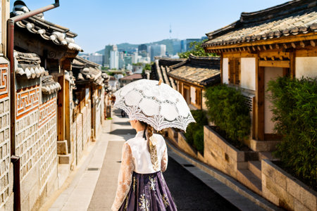 South Korea, Seoul. Woman in hanbok in Bukchon Hanok Village. Girl wearing traditional dress and...