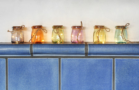 Led lights in colored glasses on tiled stoveの写真素材