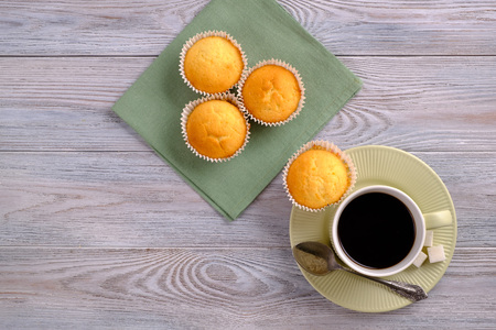 Lemon muffins with coffee on a wooden table
