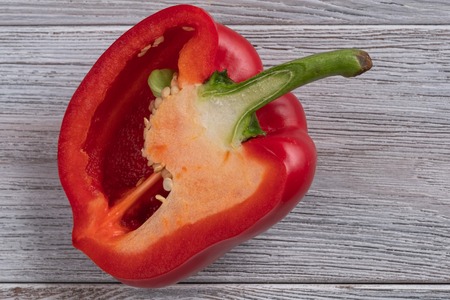 Healthy food. Red pepper cut in half close up on a wooden tableの写真素材