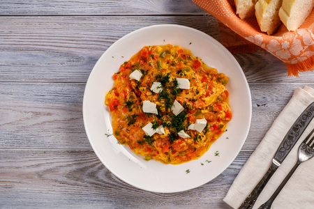 Delicious and healthy breakfast. Turkish Scrambled Eggs with Tomatoes and Peppers on wooden table close-upの写真素材