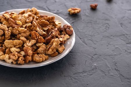 Fresh, peeled walnuts before chopping in a blender on a gray background close-up