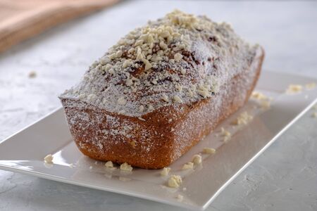 Tasty and fragrant cupcake with strawberries and almonds with a crispy crust on a white plate...