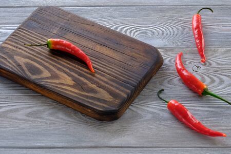Fresh red hot chili peppers on a wooden table close-upの写真素材