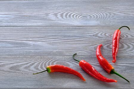 Fresh red hot chili peppers on a wooden table close-up