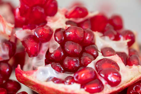 Bright and juicy pomegranate on a wooden table close-up