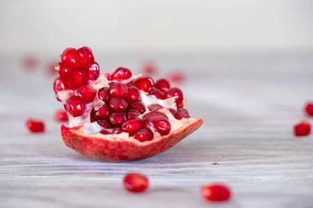 Bright and juicy pomegranate on a wooden table close-upの写真素材