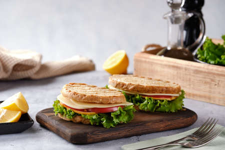 Sandwich with cheese, tomato and fresh salad, made of whole wheat bread with a crispy crust on a...