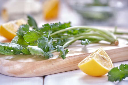 Spicy herb watercress salad with olive oil and lemon on a wooden board on a white plate close upの写真素材