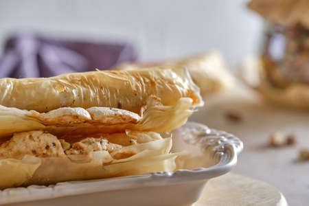 Fragrant cappuccino coffee with puff tubes with meringue and pistachios close-up