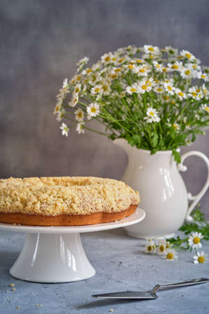 Fragrant cupcake on a white high stand on a gray background close-up