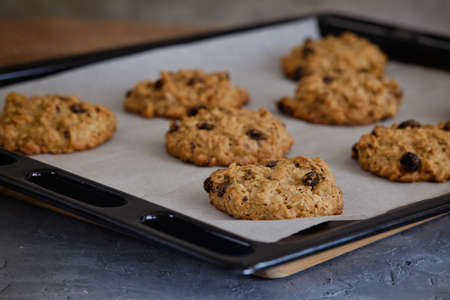 Fragrant oatmeal biscuits on a plate with openwork edges on a gray table close-upの写真素材