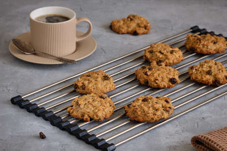 Fragrant oatmeal biscuits on a plate with openwork edges on a gray table close-upの写真素材
