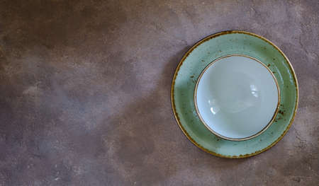 Green ceramic plate with a bowl on a concrete tableの写真素材