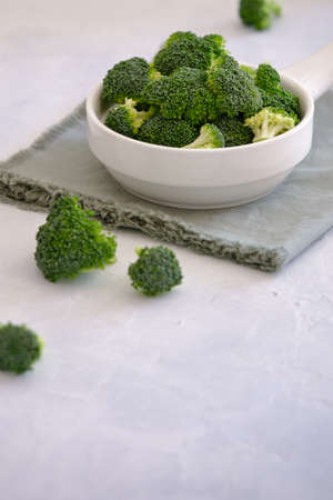 Fresh green broccoli in white bowl on light table.. Vegetarian foodの写真素材