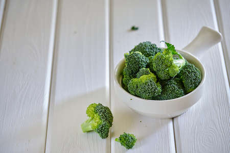 Fresh green broccoli in white bowl on light table.. Vegetarian foodの写真素材