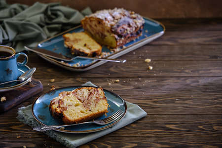 Home pound cake with lemon and strawberry filling on a blue plate on a wooden table.