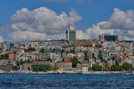 Istanbul, Turkey, July 18, 2022. Bosphorus Strait and the European part of the city. People float on a ferry along the shore, ferries and boats stand at the pier.のeditorial素材