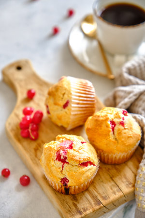 Muffins with red currants on a wooden boardの写真素材