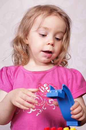 Young girl playing with plastic blocksの写真素材