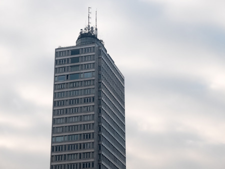 High rise apartment building with broadcast, cellular and microwave antennae above round base