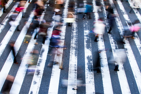 People crossing a zebra crossing with motion blur and focus to the stripes on the street, high angle viewの写真素材