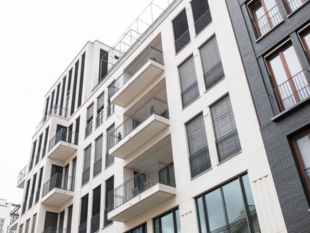 View looking up toward modern urban apartments with balconies and black and white facades