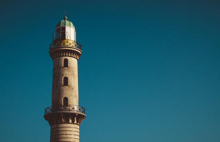 Exterior view of old tall lighthouse beacon with copy space in clear blue skyの写真素材