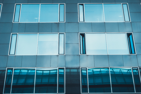 detailed view of glass facade with blue windowsの写真素材