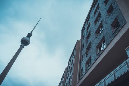Low angle view of plain urban city apartments besides tall pointed monument under an overcast dayの写真素材