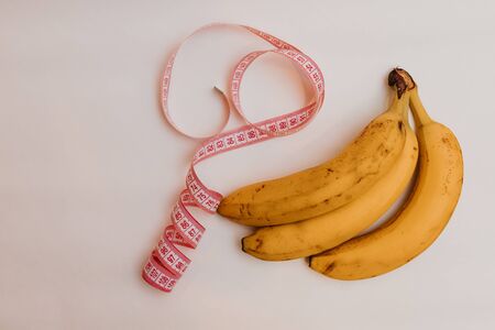 Banana isolated on white background.Tape measure.Food supplies crisis food stock for quarantine isolation period on white.Food delivery, Donation, coronavirusの写真素材