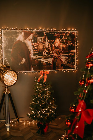 Modern New Years decor for the living room and bedroom. Christmas tree, decorated with New Years toys, stands near the fireplaceのeditorial素材