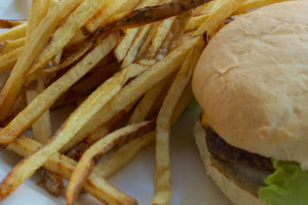 Cheeseburger or hamburger with fries on a white plate の写真素材