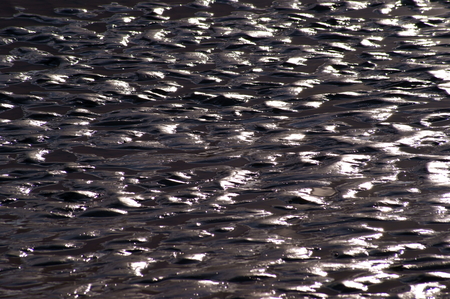 Ripples of light in dark wet sandの写真素材