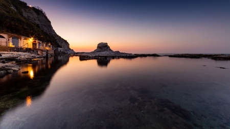 Passetto beach with typical fisherman caves in Ancona - Marche - Italy, at sunset