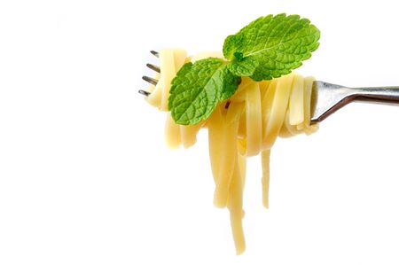 An image of tasty yellow pasta on a steel forkの写真素材