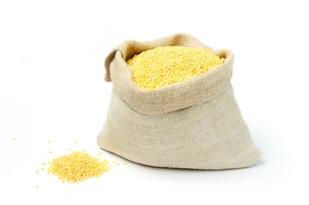 An image of raw yellow millets in a burlap bagの写真素材