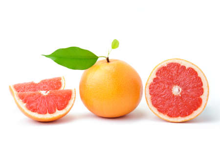 Ripe grapefruit with leaves and slices on whiteの写真素材
