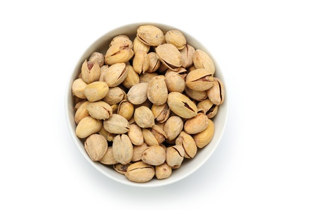 Dry salted pistachio fruit in bowl on white backgroundの写真素材
