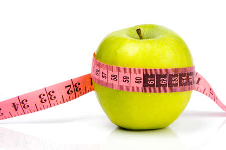 An image of a green ripe apple and a measuring tapeの写真素材